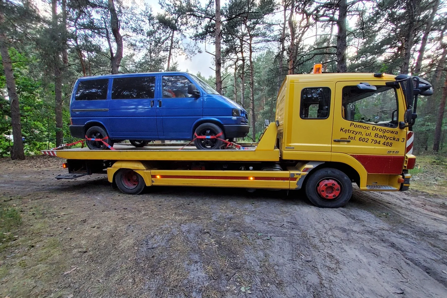 Der blaue T4 steht im Wald auf einem gelben Abschleppwagen