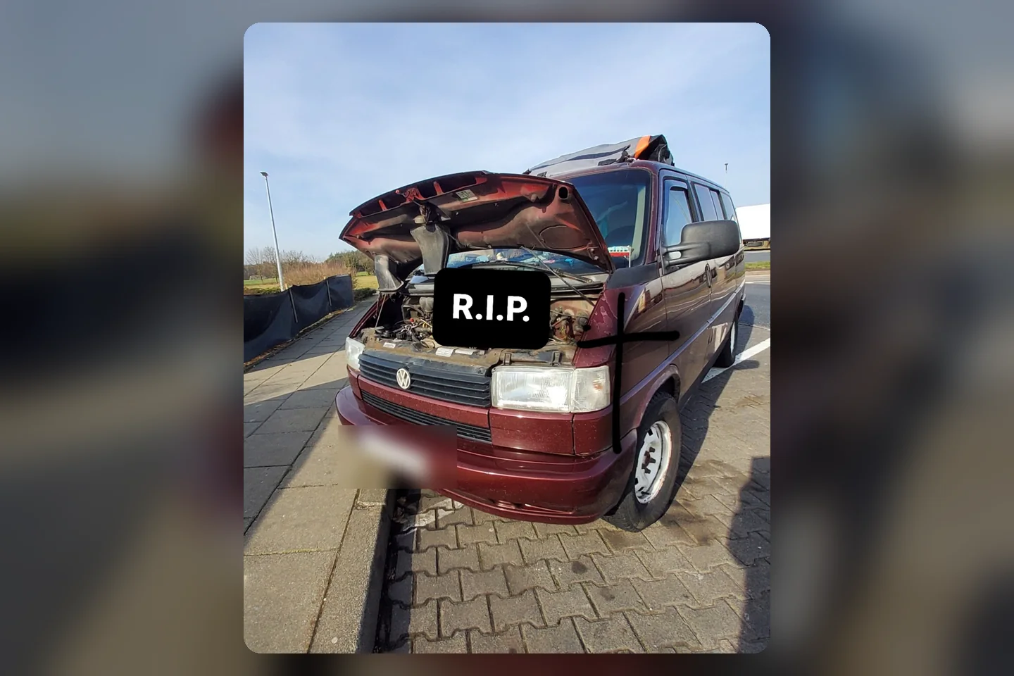 Der rote T4 mit geöffneter Motorhaube und der Aufschrift R.I.P. nach seinem Motorschaden