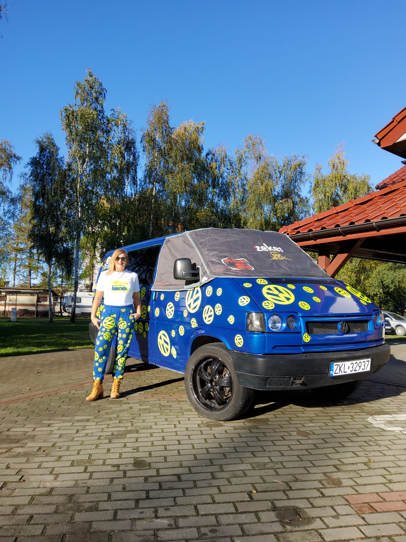 Tussy steht neben ihrem blauen VW T4 Bulli